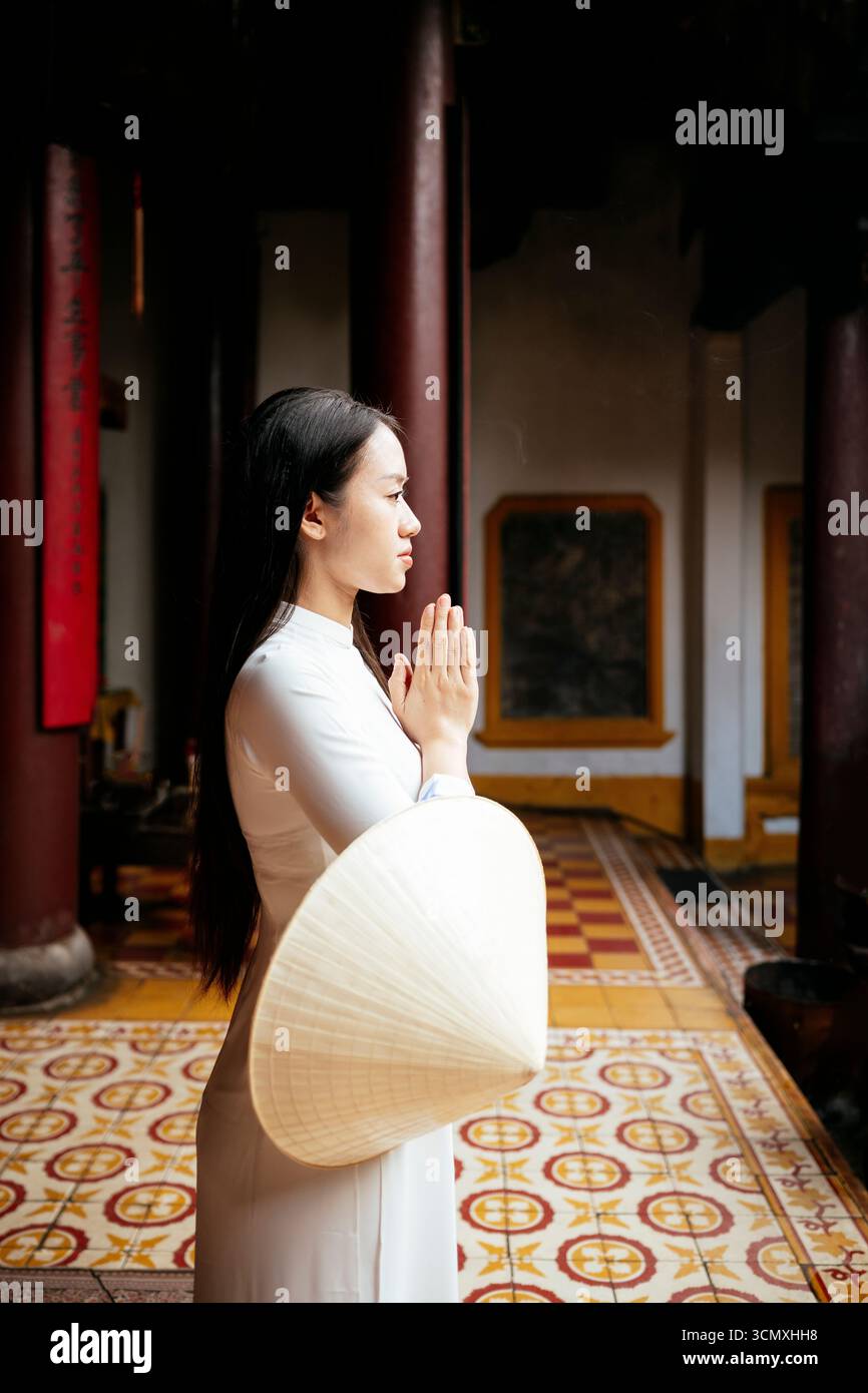 Vietnamesische Frau in ao dai im Quang Cong Tempel, Hoi an, Provinz Quang Nam, Vietnam Stockfoto