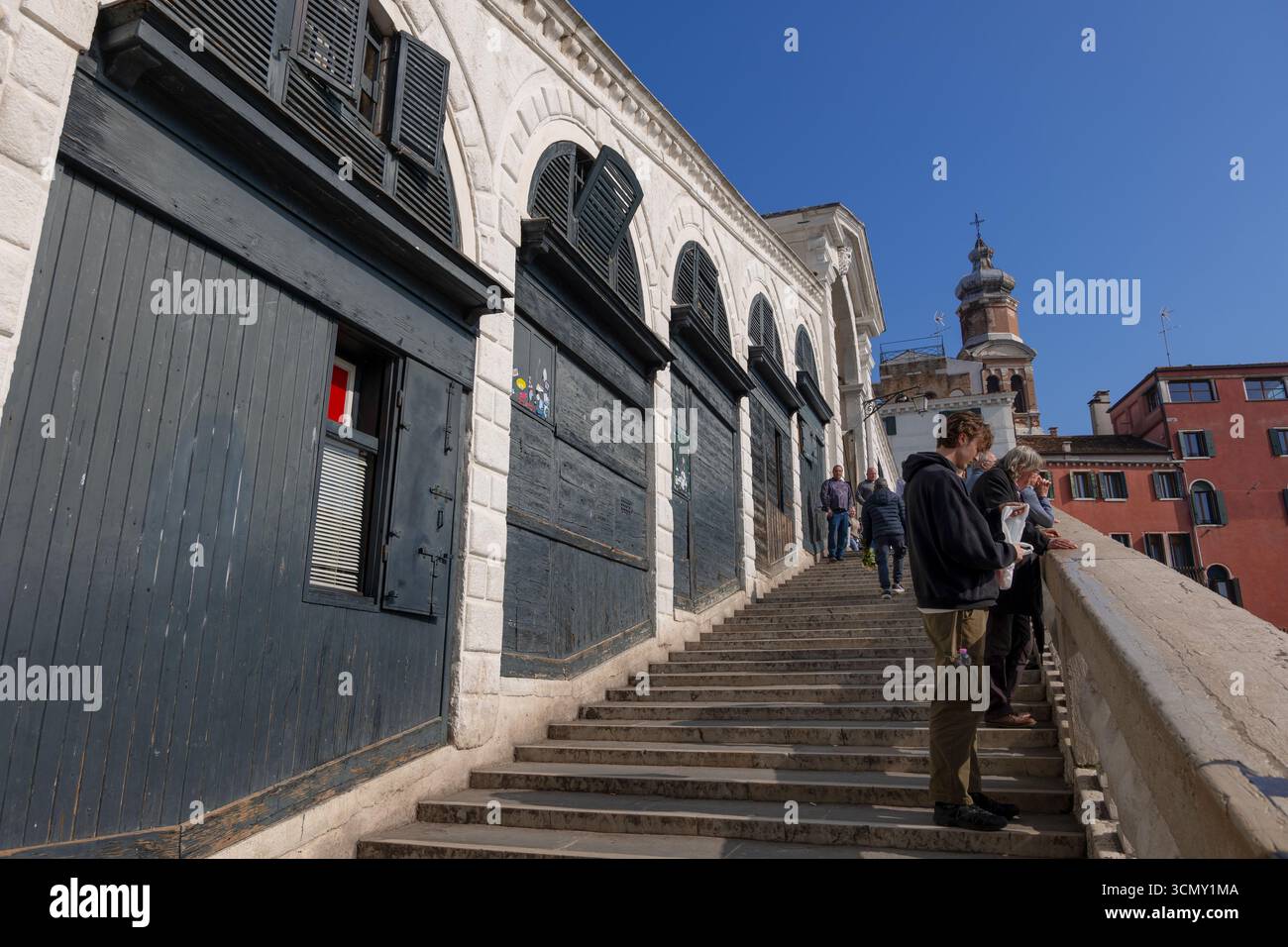 Leute auf der Treppe der Rialto-Brücke in Venedig, Italien. Eine bekannte Fußgängerbrücke aus dem Jahr 1591, die den Canal Grande überspannt. Stockfoto