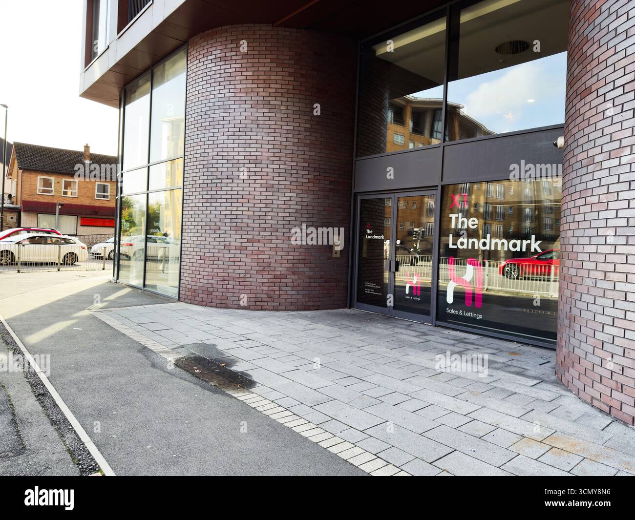 Salford, Großbritannien - 16. September 2025: Ein städtisches Gebäude X1 the Landmark Entry mit Glaspaneelen und Ziegelwänden in Salford, Großbritannien. Stockfoto