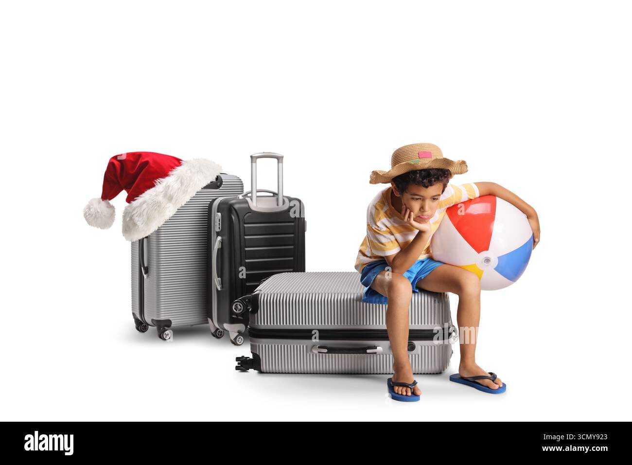 Chrsitmas Reisekonzept, Junge sitzt auf einem Koffer und wartet isoliert auf weißem Hintergrund Stockfoto