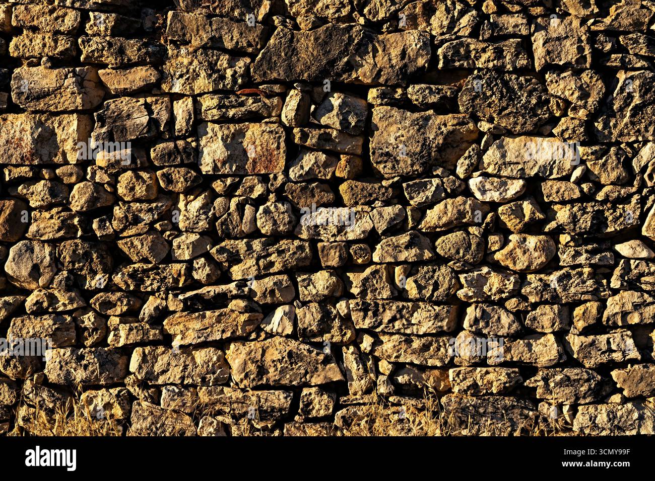 Blick auf die alte Mauer mit Steinen in warmen Farbtönen. Konzept für Hintergründe und Texturen. Stockfoto Blick auf die alte Mauer mit Steinen in warmen Farbtönen. Konzept für Hintergründe und Texturen. Stockfoto