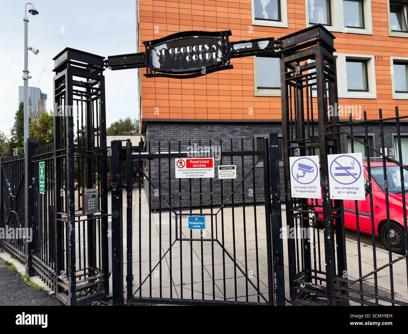 Manchester, Großbritannien - 16. September 2025: Schwarzes Eingangstor mit CCTV- und Rauchverbotsschildern in Manchester, Großbritannien Stockfoto