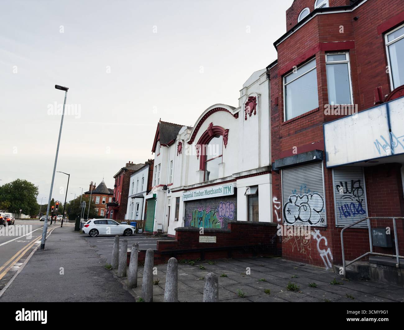 Manchester, Großbritannien - 16. September 2025: Straßenansicht der Manchester-Architektur mit Graffitis an den Schaufensterfronten und Autos in der Nähe. Imperial Timber Stockfoto