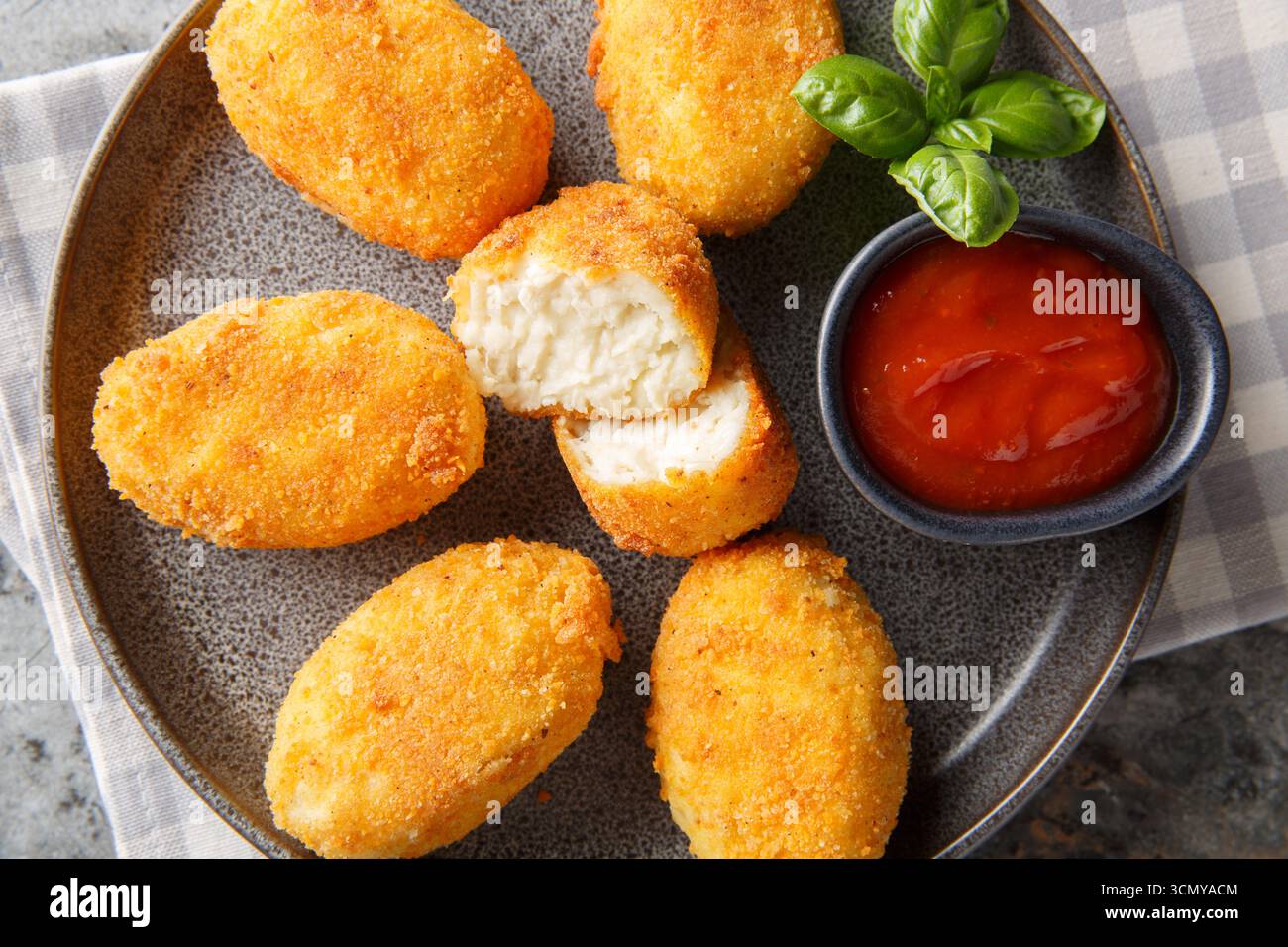 Panierte und frittierte Hähnchenkroketten serviert Tomatensauce in Nahaufnahme auf einem Teller auf dem Tisch. Horizontale Draufsicht von oben Stockfoto