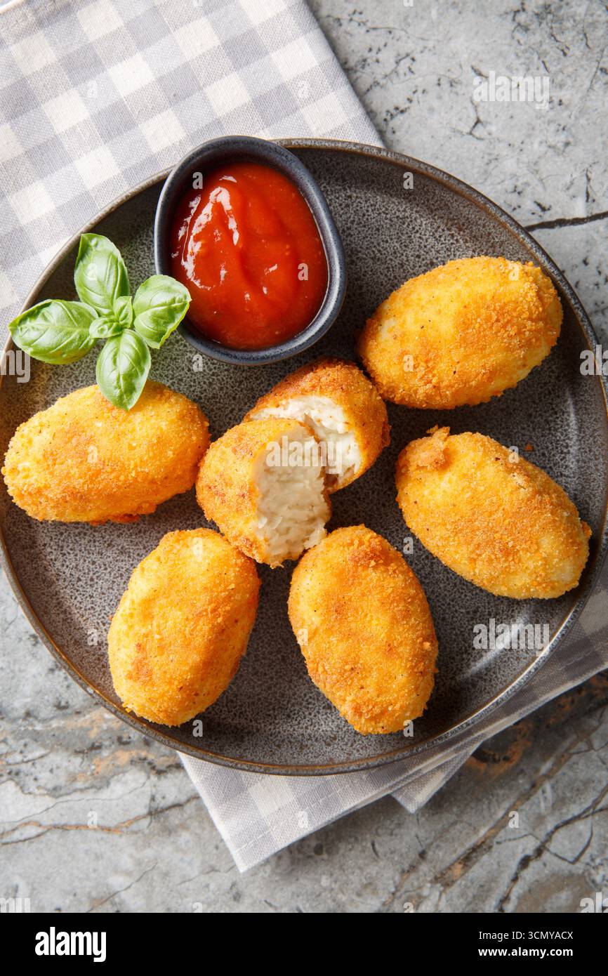 Chicken Croquetas de Pollo mit Ketchup Nahaufnahme auf einem Teller auf dem Tisch. Vertikale Draufsicht von oben Stockfoto