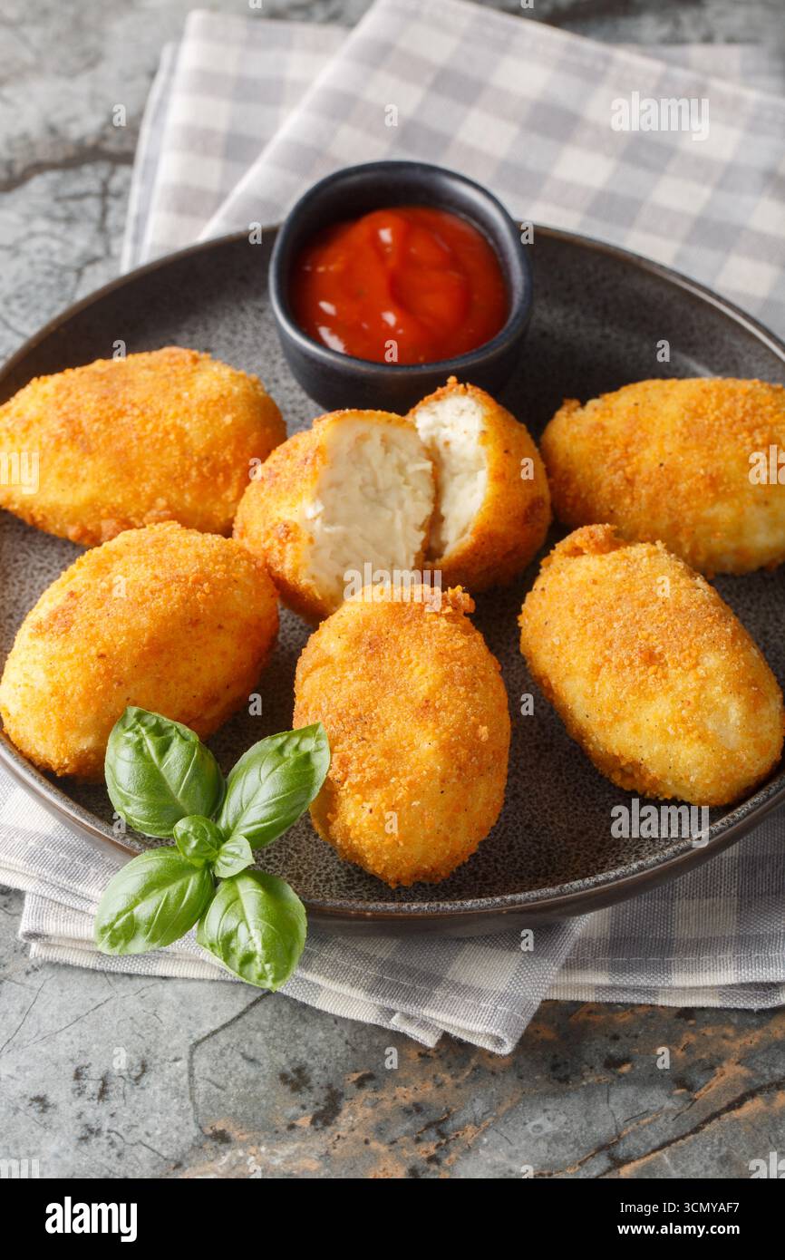 Chicken Croquetas de Pollo mit Ketchup Nahaufnahme auf einem Teller auf dem Tisch. Vertikal Stockfoto