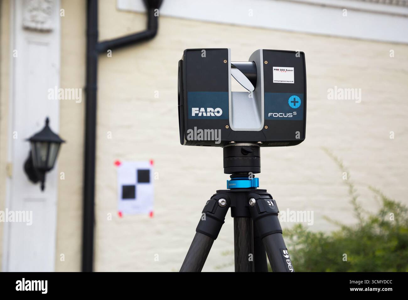 Ein Laserscanner auf einem Stativ, der während einer Vermessung für eine Planungsanwendung in einem Wohnhaus/Gebäude verwendet wird. Ziele sind an der Wand. UK. (140) Stockfoto