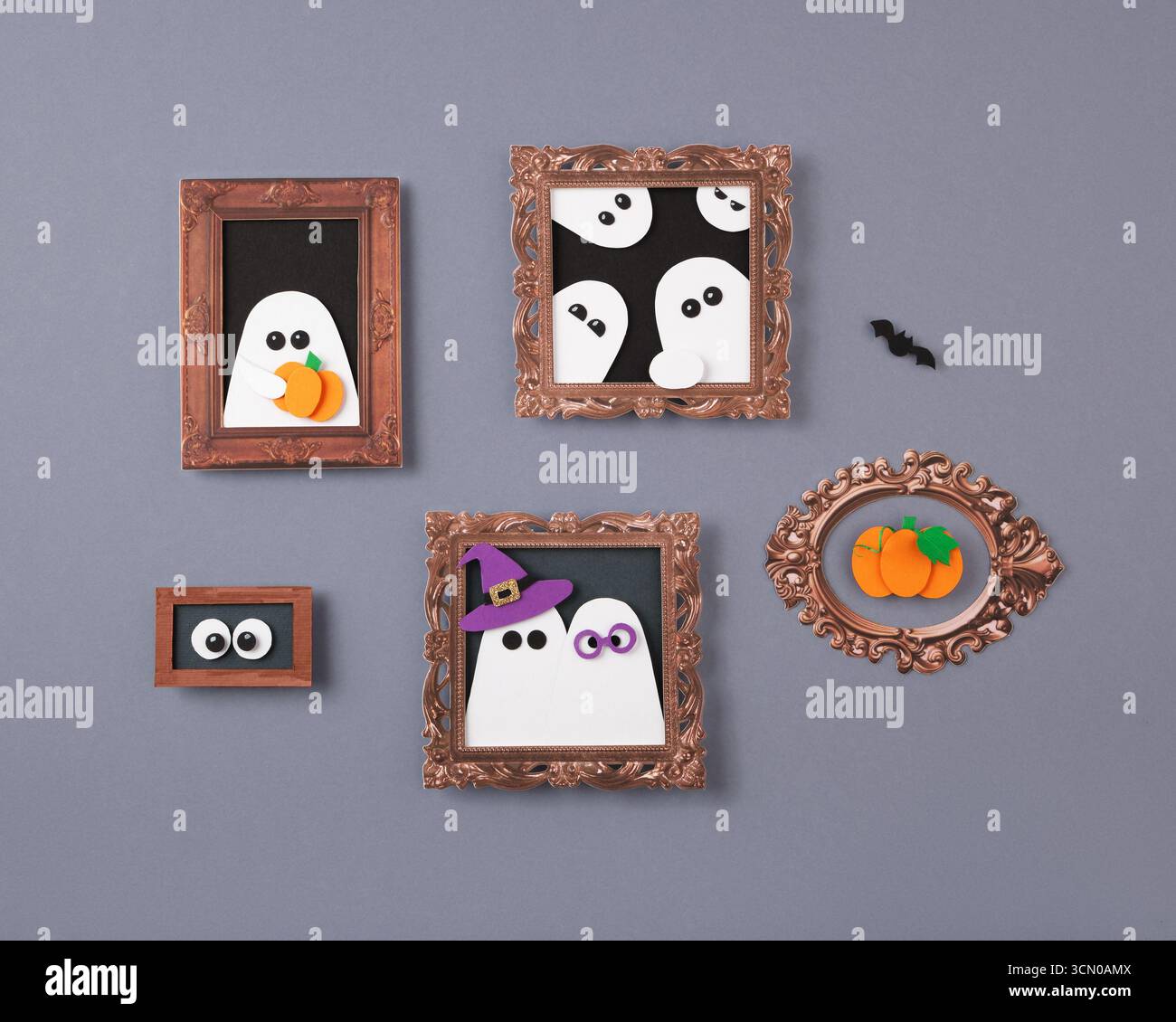 Halloween-Papier bastelt mit gerahmten Geistern, Kürbissen und Augen auf grauem Hintergrund Stockfoto