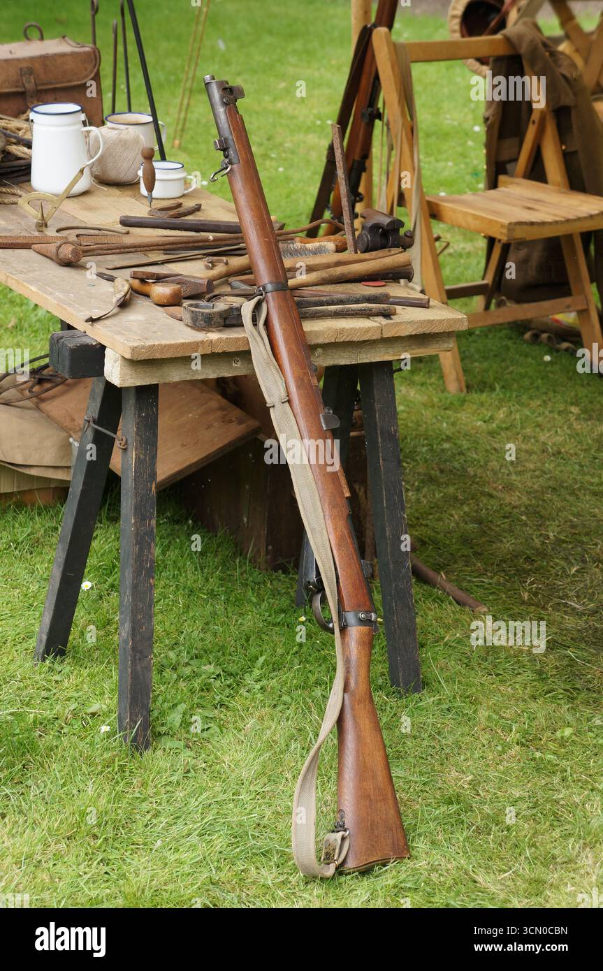 Ein hölzernes Gewehr aus dem 1. Weltkrieg lehnt sich an einen Tisch. Stockfoto