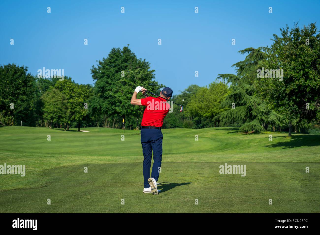 Professionelle Golfspieler schlagen an einem schönen sonnigen Tag auf dem Golfplatz den Ball Stockfoto