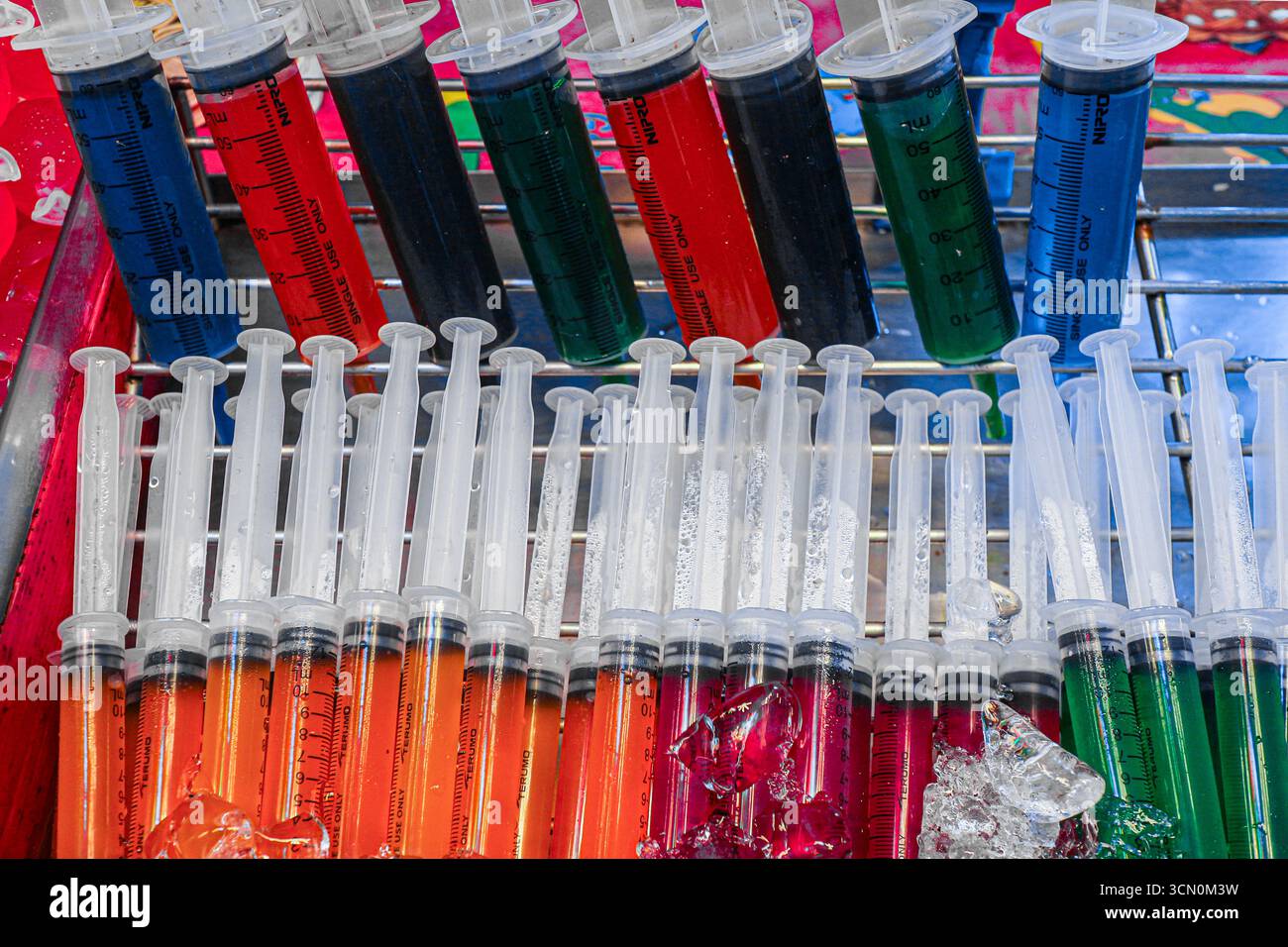 Buntes thailändisches Dessert aus Gelee-Bonbons in Spritzenaufnahmen auf Eis mit verspieltem Design und hellen Tönen. Stockfoto