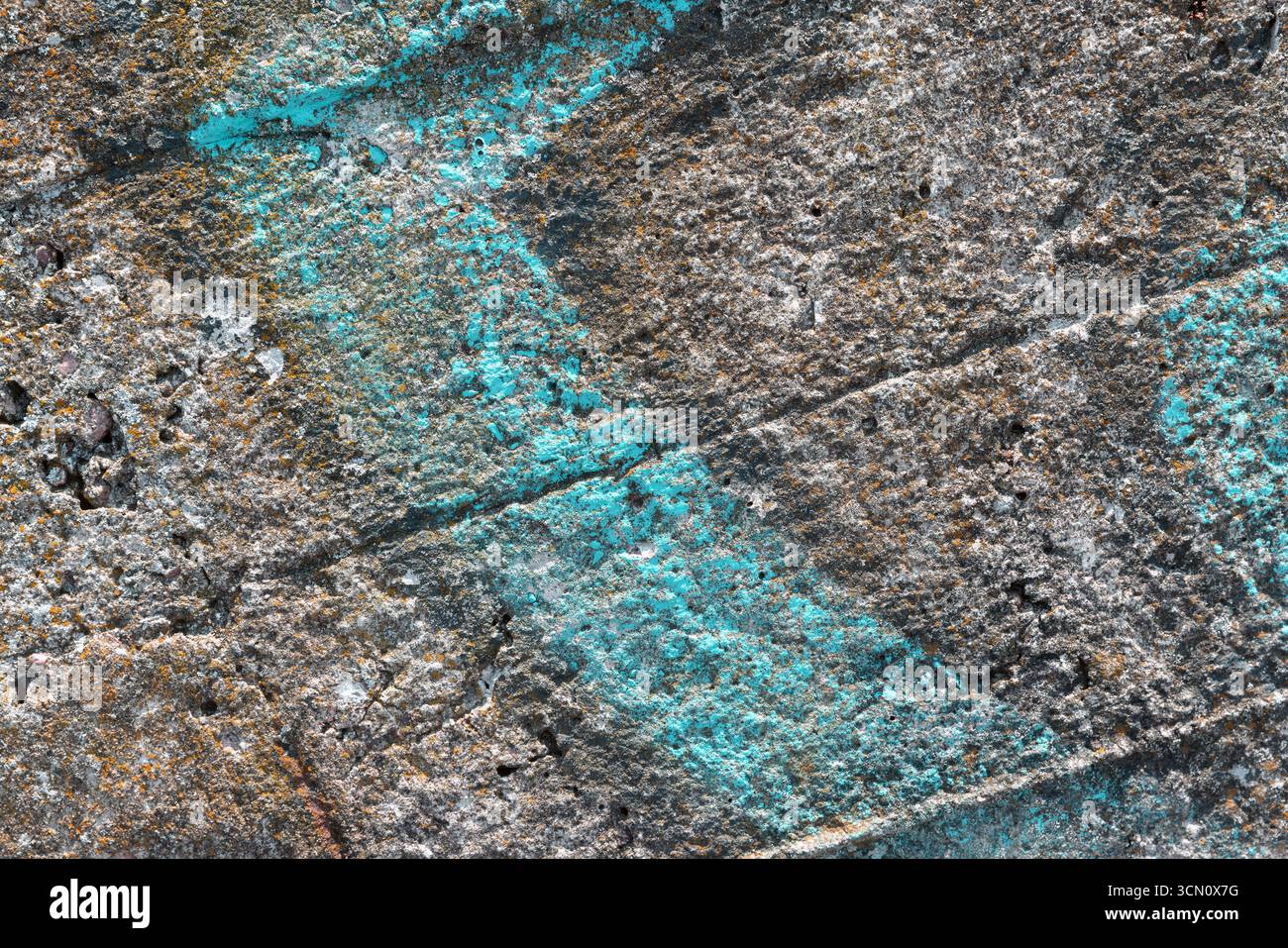 Eine Nahaufnahme einer strukturierten Betonoberfläche mit leuchtenden blauen und rostfarbenen Markierungen, die komplizierte Muster und Details zeigen. Abs Stockfoto