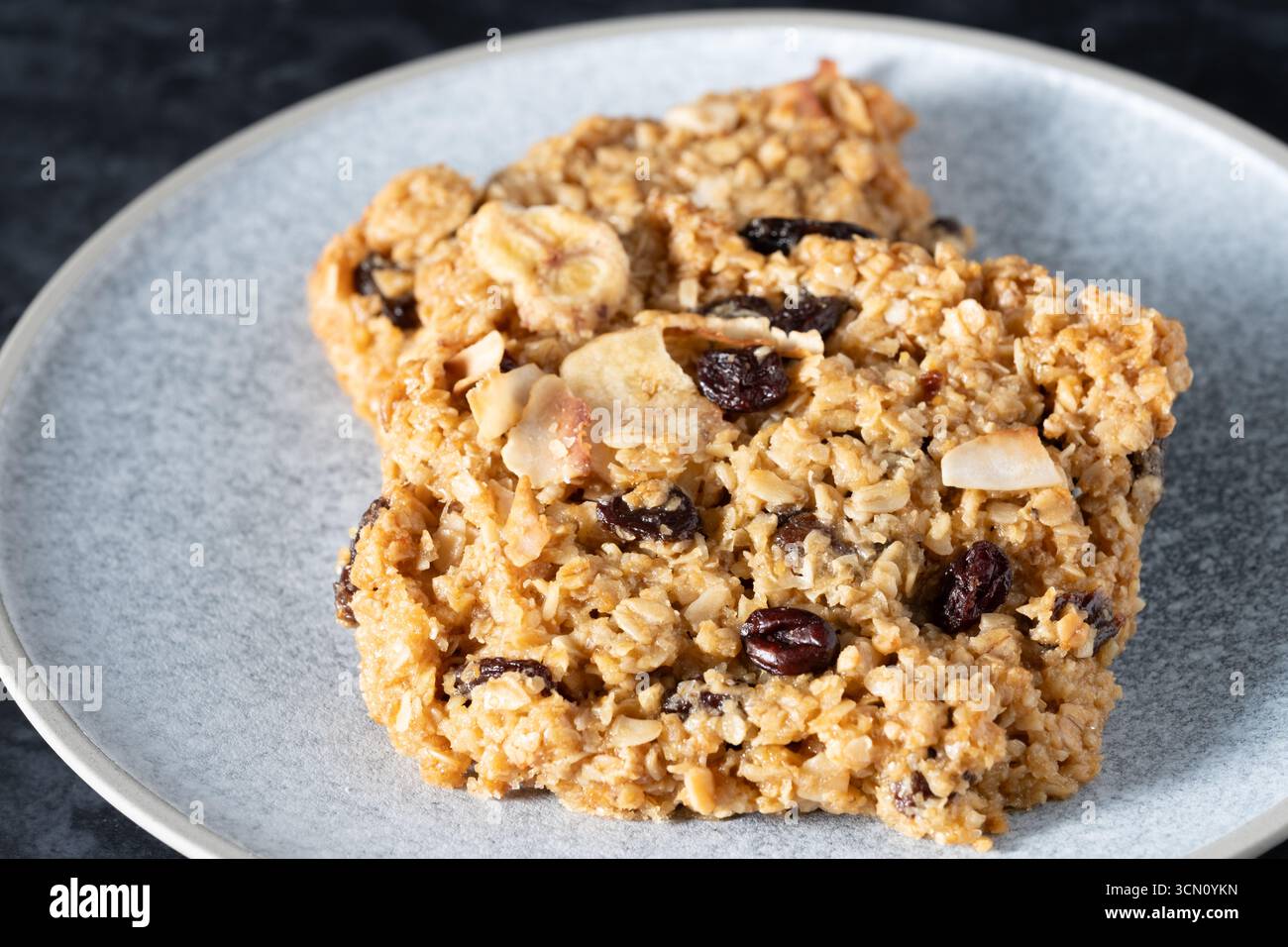 UK. UK. Zwei Bars oder Portionen traditioneller Flapjack. Hergestellt aus Haferflocken, braunem Zucker und getrockneten Früchten. Stockfoto
