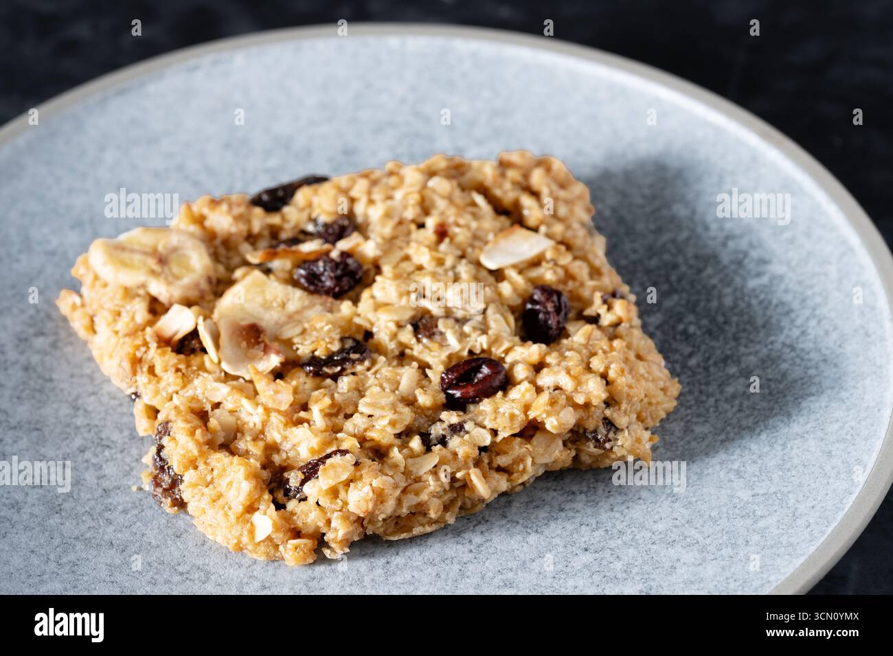 UK. Eine Portion oder Portion traditioneller Flapjack. Hergestellt aus Haferflocken, braunem Zucker und getrockneten Früchten. Stockfoto
