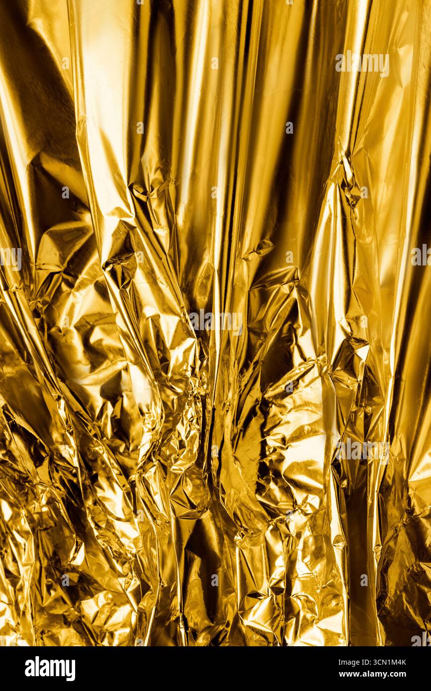Goldene, zerknitterte Metallic-Folien-Textur als Hintergrund Stockfoto