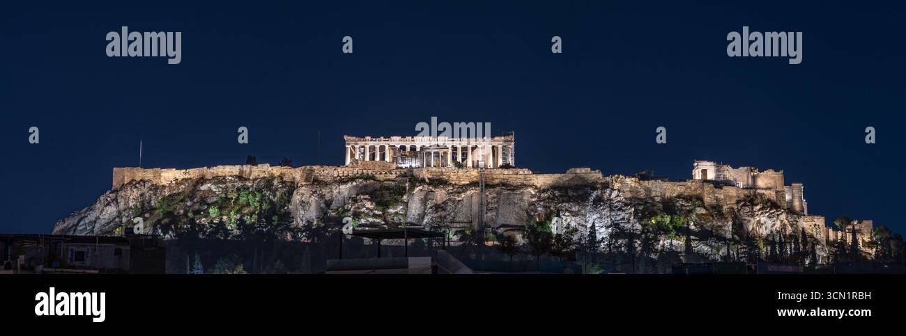 Panoramablick auf den beleuchteten Akropolis-Hügel mit Parthenon- und Propyläentempeln bei Nacht in Athen, Griechenland. Mai 2025. Stockfoto