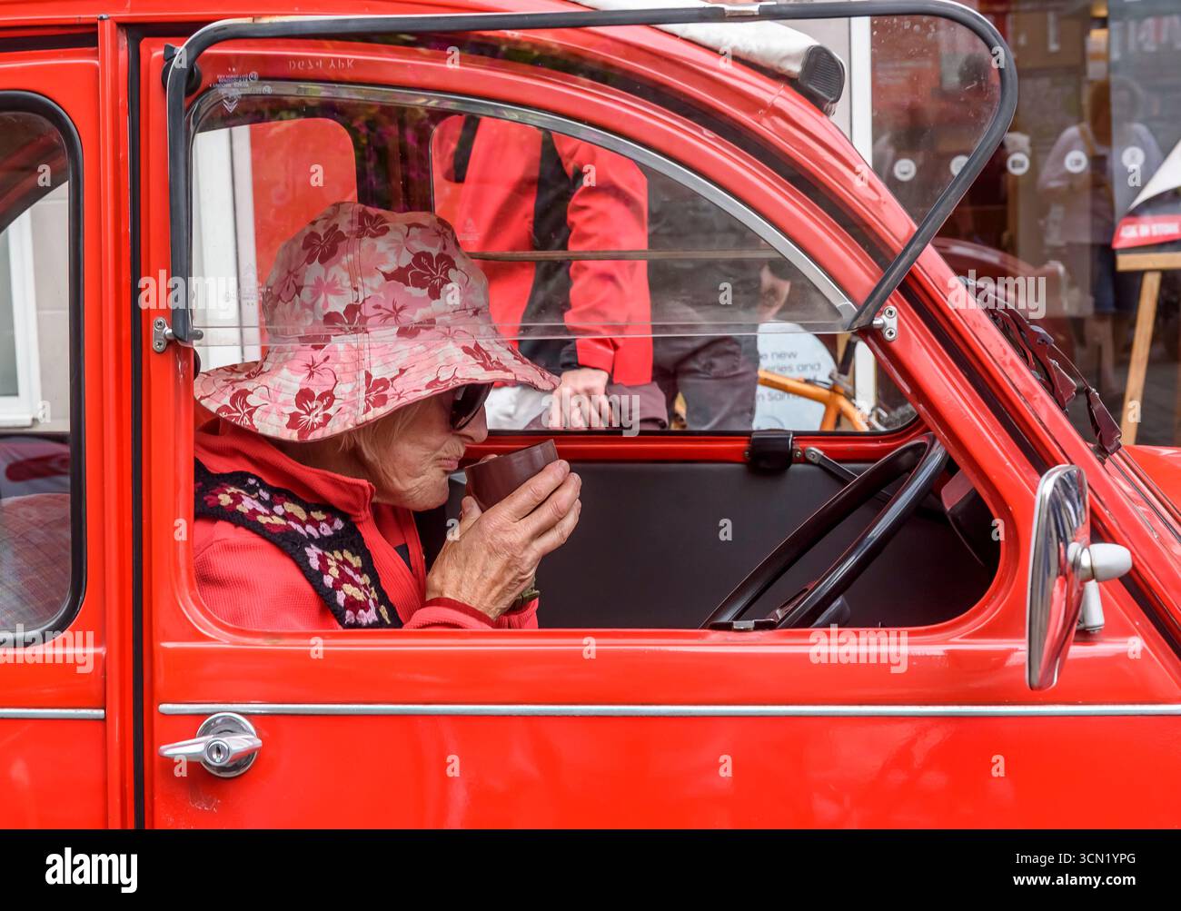 Rote Dame im roten Auto Stockfoto