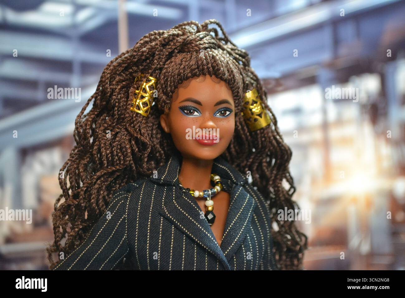 Barbie am Arbeitsplatz. Brooklyn Barbie-Puppe für die Arbeit gekleidet vor einem Hintergrund einer industriellen Fabrik. Stockfoto