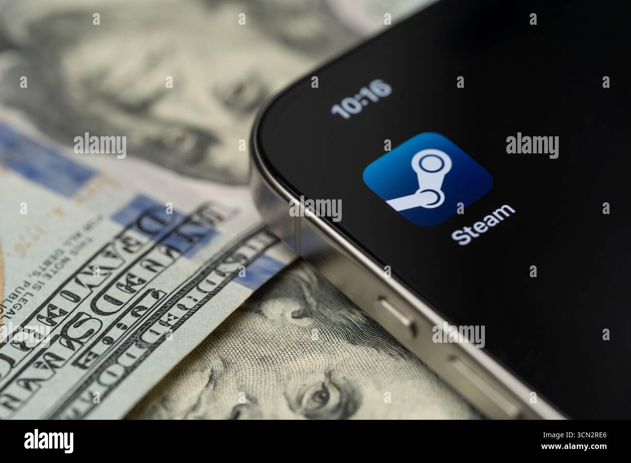 New York, USA – 12. September 2025: Steam-App auf Smartphone-Bildschirm mit Dollarhintergrund in Nahaufnahme Stockfoto