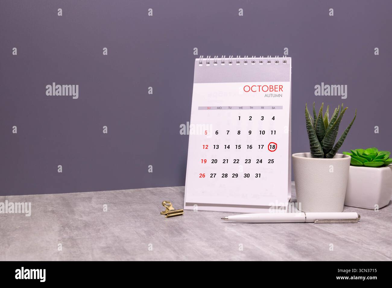 Holzkalender mit Datum 18. Oktober. Monatskalender für Planung und Management-Konzept mit Wecker auf hölzernem Hintergrund Stockfoto