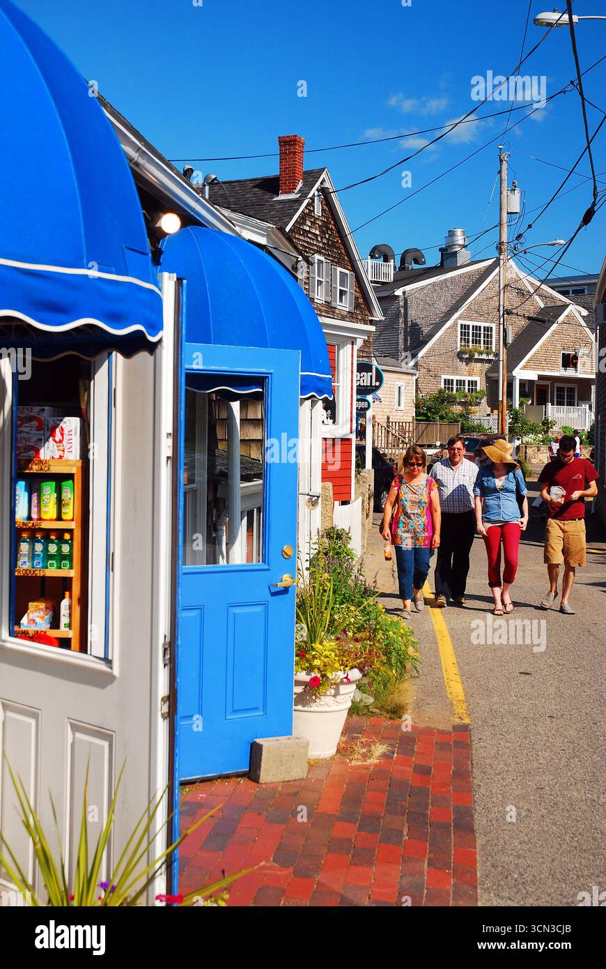 Die Leute laufen entlang des Bearskin Neck, einem Einkaufsviertel in {Rockport, Massachusetts, das mit kleinen Geschäften und Cafés bevölkert ist Stockfoto