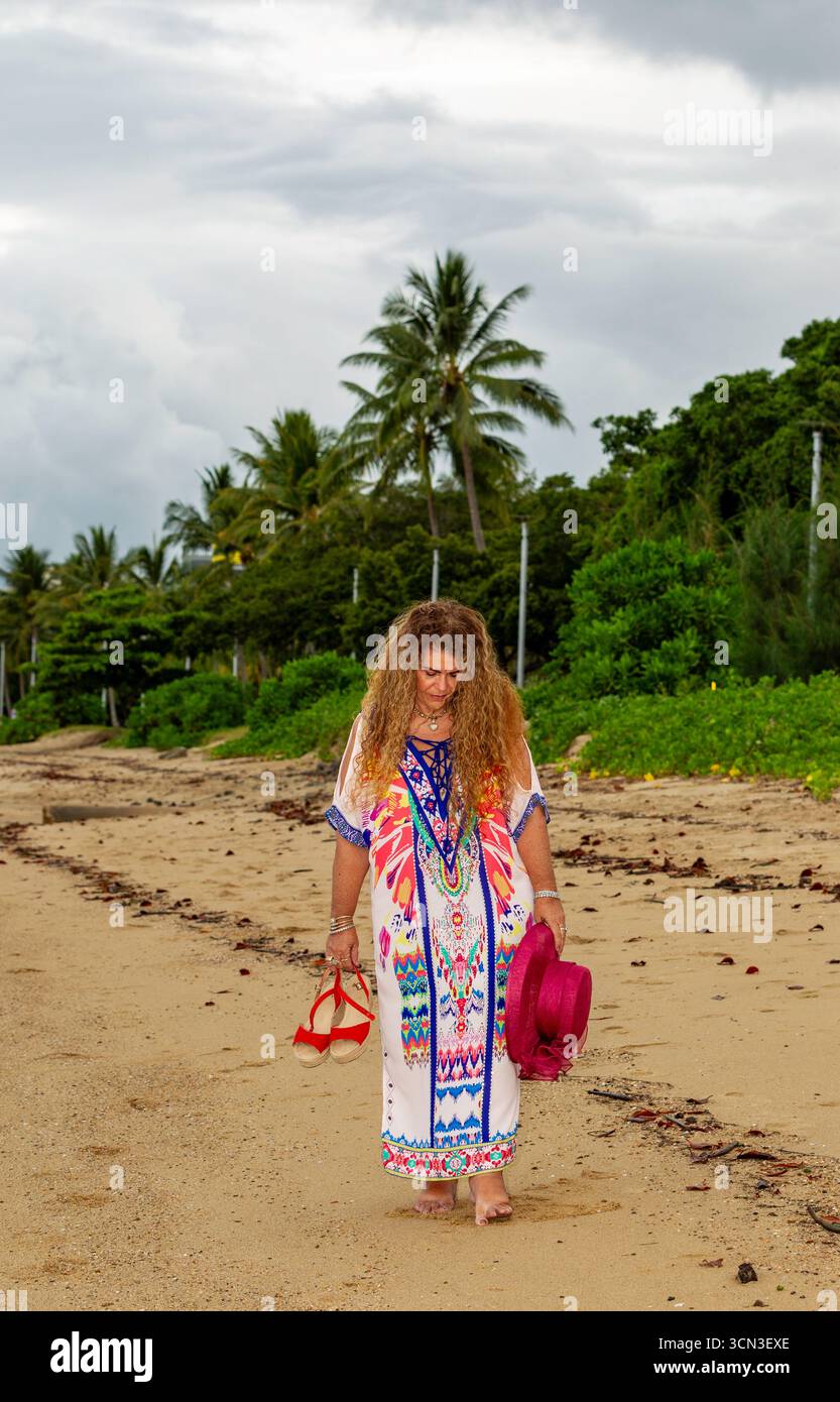 Lady denken Zehe in Sand Wandern Strand Farbe volles Kleid langes lockiges braunes Haar 50 plus Modelle reife Modelle Modellierung australien australien australien australien Stockfoto