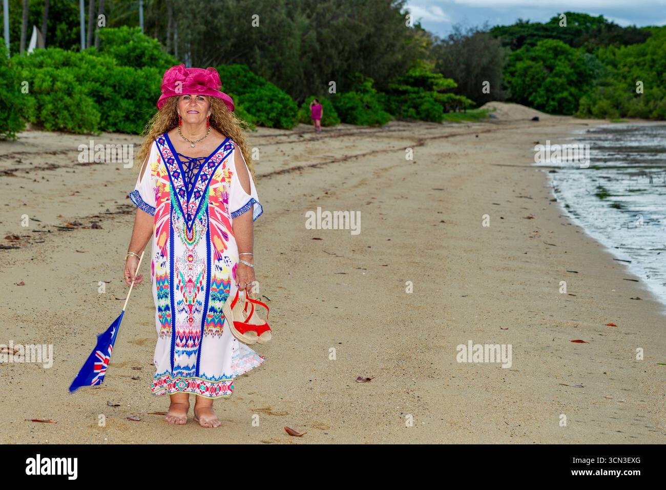 Lady australian Flag Walking Beach Color volles Kleid langes lockiges braunes Haar 50 und Modelle reifer Modelle, die australien australisch modellieren Stockfoto