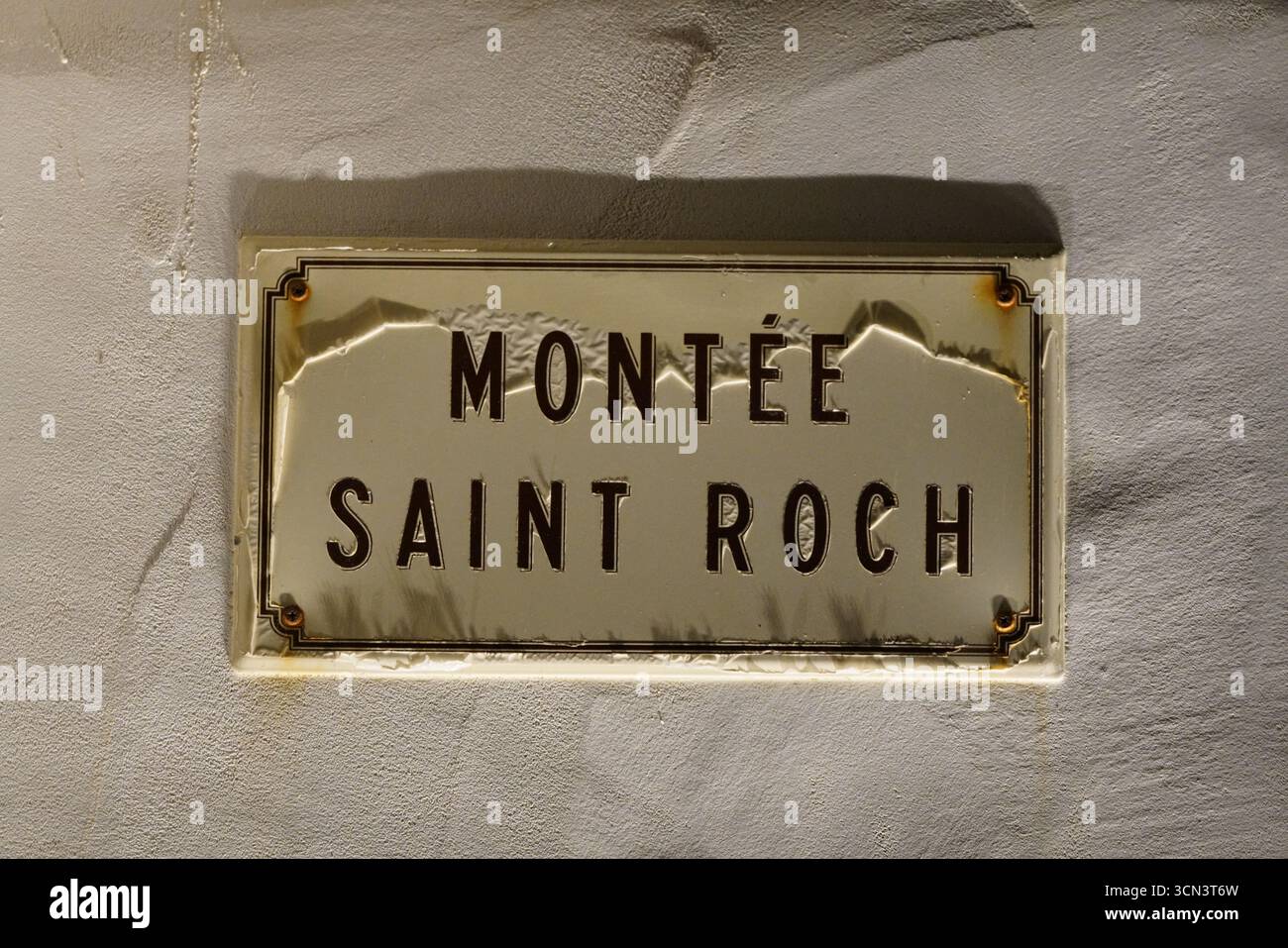 Montee Saint roch Street Schild auf verwitterter Wand, Vintage-Metallplakette, französisches Erbe. Bonifacio, Korsika, Frankreich Stockfoto