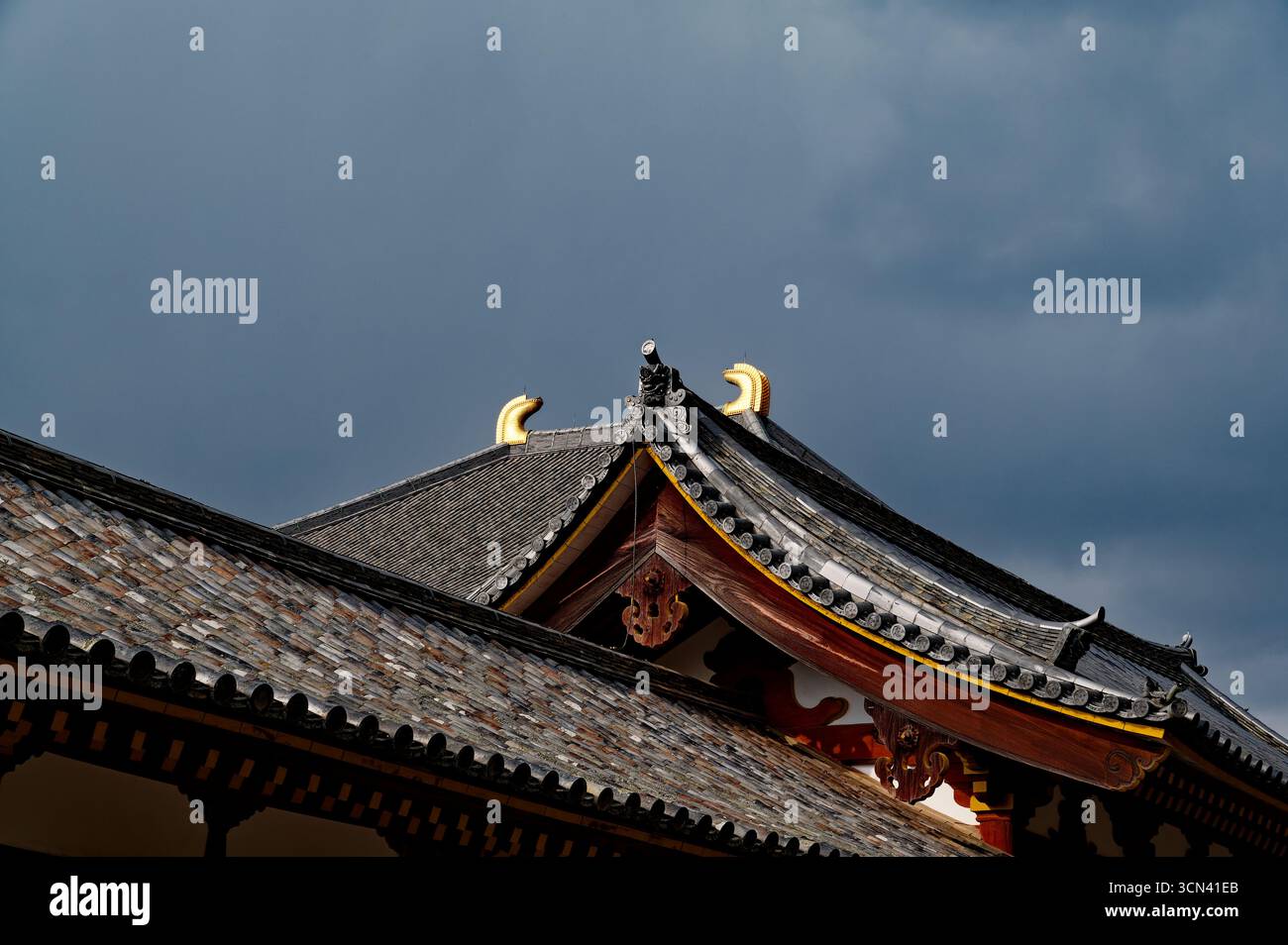 Verzierte Ziegeldächer des Todai-JI-Tempels in Nara vor einem stürmischen Himmel Stockfoto