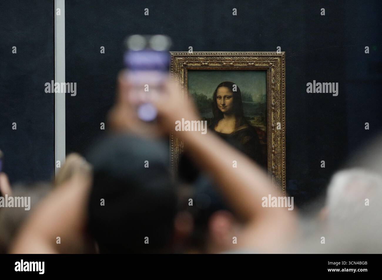 Paris, Frankreich - 9. Juni 2023: Touristenmassen machen Fotos vom berühmten Mona Lisa Gemälde von Leonardo da Vinci im Louvre. Stockfoto