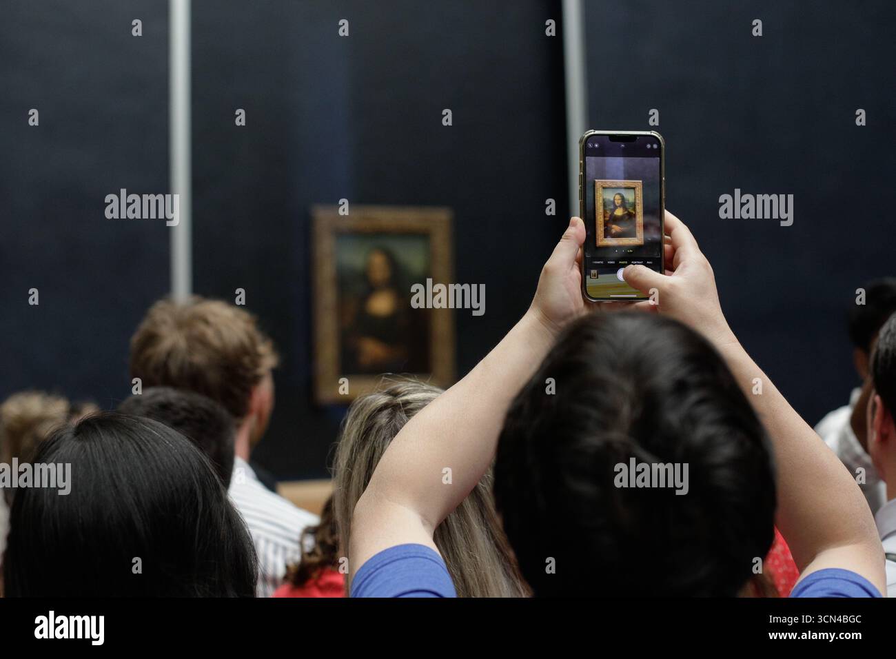 Paris, Frankreich - 9. Juni 2023: Touristenmassen machen Fotos vom berühmten Mona Lisa Gemälde von Leonardo da Vinci im Louvre. Stockfoto