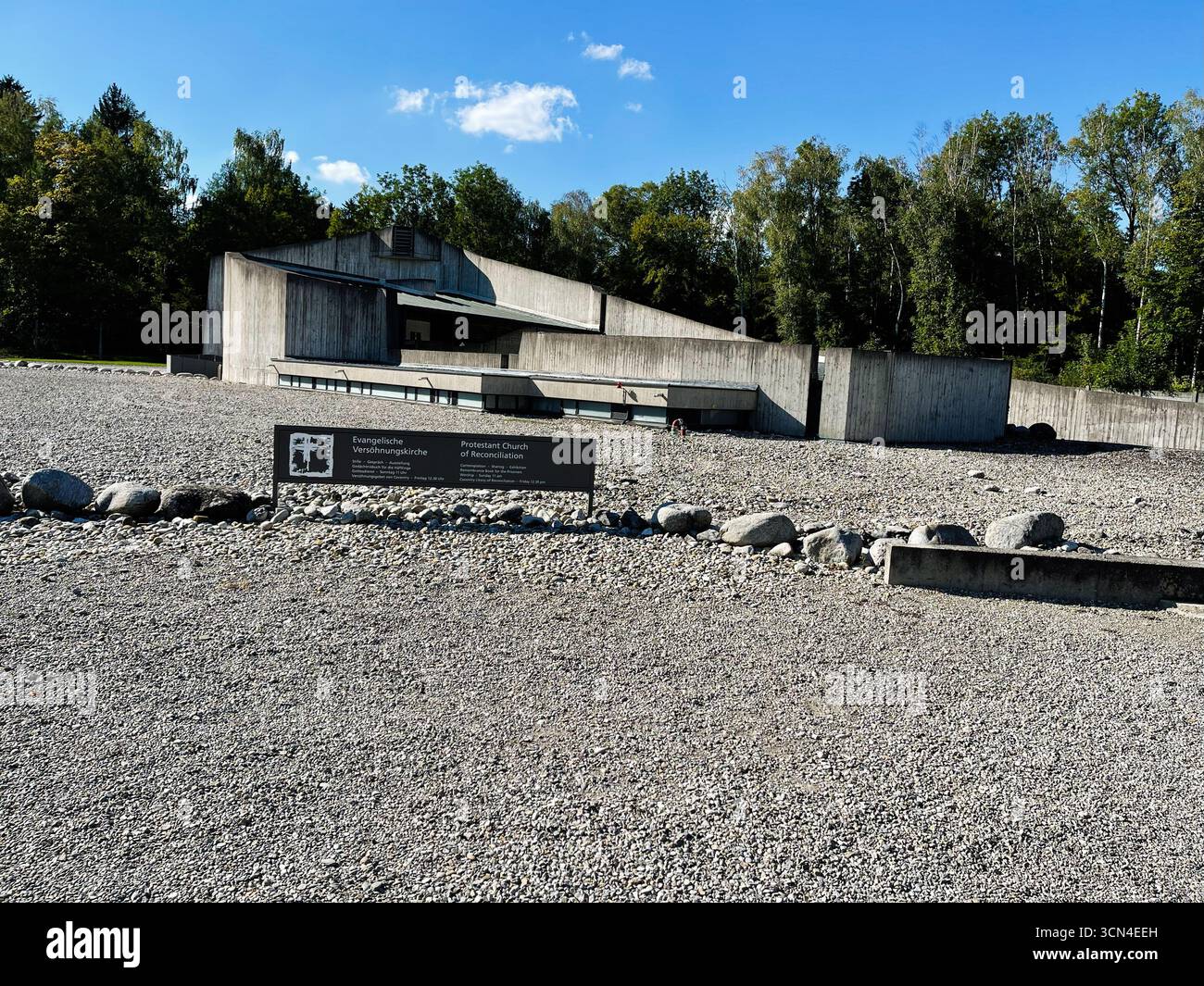 Dachau, Deutschland - 29. September 2022: Protestantische Betonkirche umgeben von Kies und Bäumen im Lager Dachau, Deutschland Stockfoto