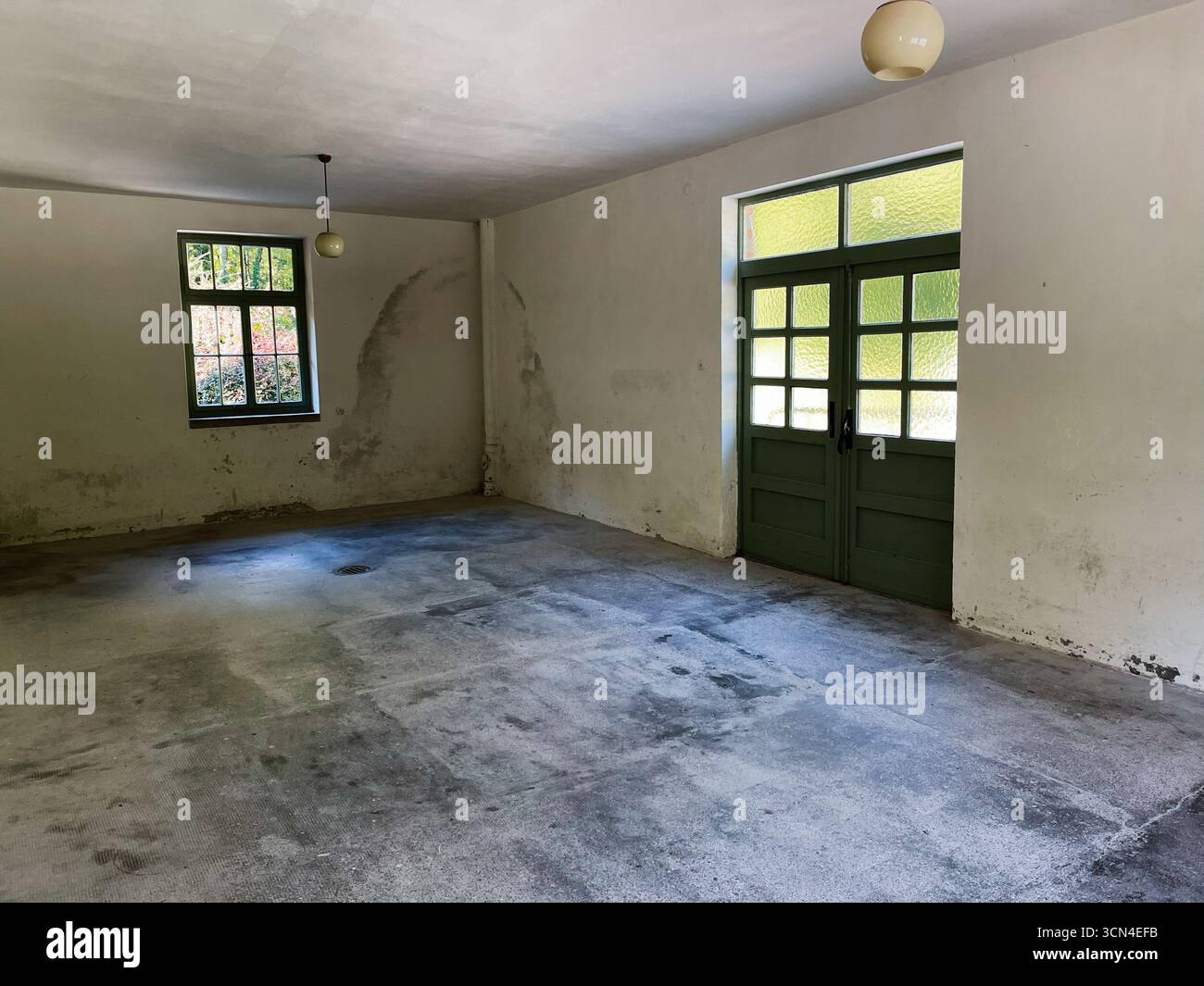 Dachau, Deutschland - 29. September 2022: Raum mit rustikalen Wänden, grün gerahmten Türen, Tageslicht und Vintage-Ambiente. Stockfoto