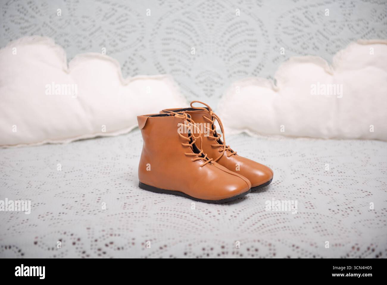 Ein Paar niedliche Lederstiefel für Kinder auf einer weichen Decke. Stockfoto