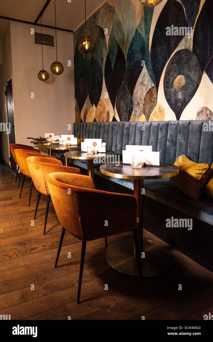 Ein wunderschön gestaltetes, modernes Restaurant-Interieur. Bietet eine einladende und intime Atmosphäre mit stilvollen Möbeln und moderner Einrichtung. Stockfoto