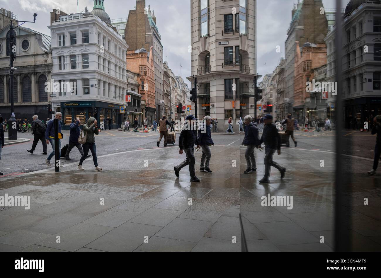 Die Pendler der City of London begeben sich während eines Herbstregen-Shows zu ihren Büros in Bishopsgate, City of London, England, Vereinigtes Königreich Stockfoto