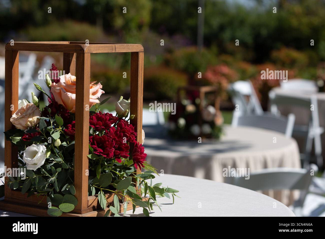 Das Herzstück der Holzkiste ist voll mit frischen Blumen, die an einem Hochzeitsempfang im Freien dekoriert werden Stockfoto