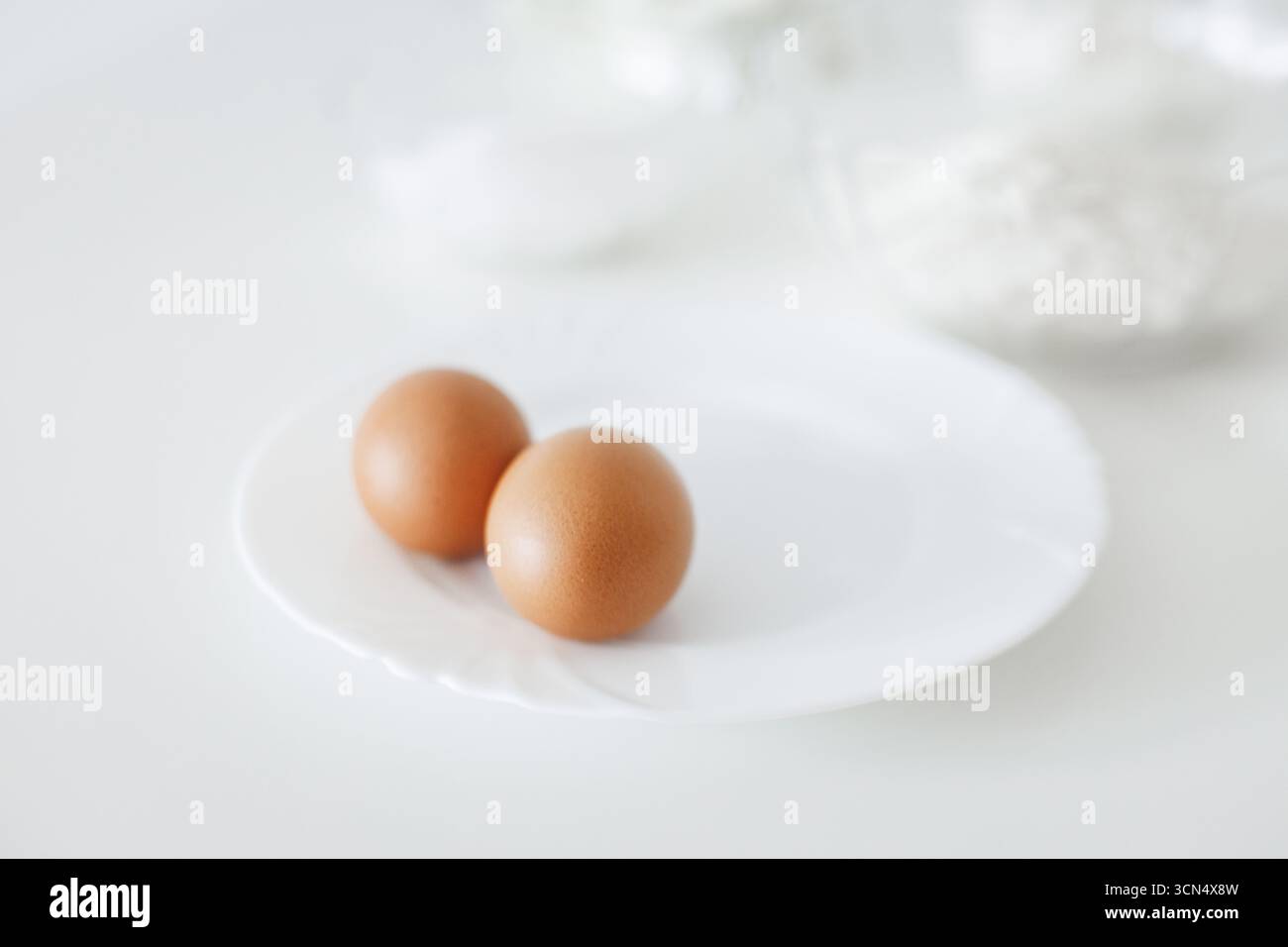 Zwei braune Eier auf weißem Teller, bereit zum Backen Stockfoto
