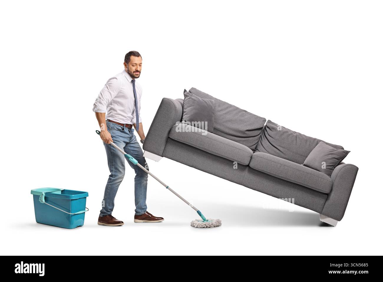 Mann putzt mit einem Mopp unter einem Sofa isoliert auf weißem Hintergrund Stockfoto