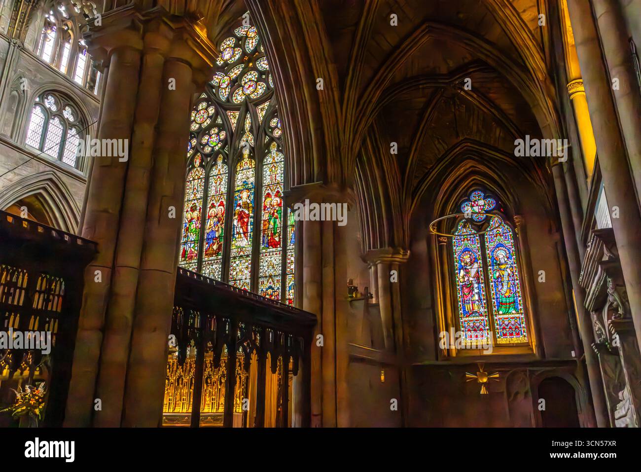 Das Innere der Ripon Cathedral, North Yorkshire, mit gotischen Bögen, Rippengewölben, Steinsäulen und kunstvollen Buntglasfenstern in der historischen Kirche Stockfoto