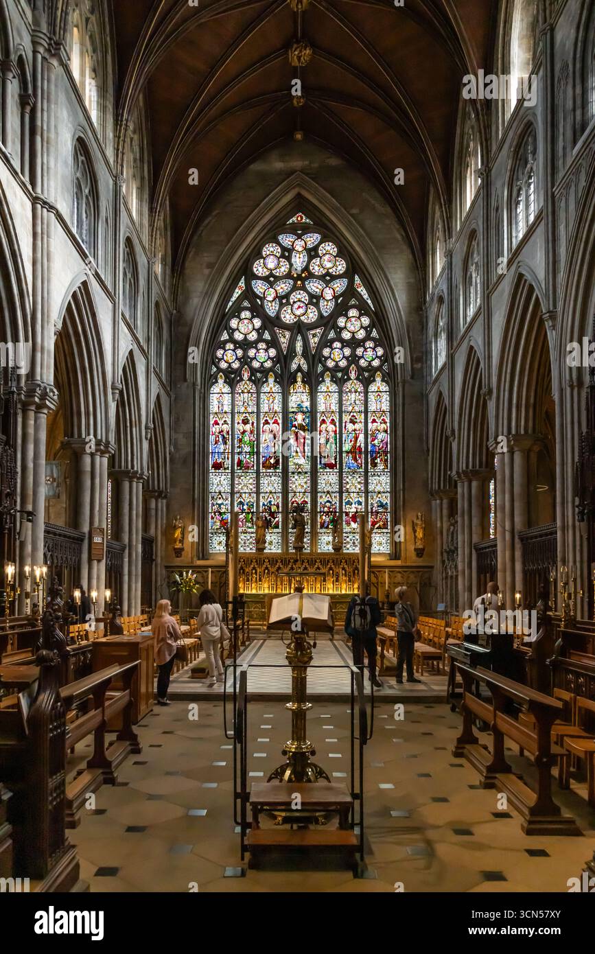 Altarinnenraum der Ripon Cathedral, North Yorkshire, mit gotischen Bögen, geriffelten Gewölben, verzierten Buntglasfenstern und Holzbänken in der historischen Kirche Stockfoto