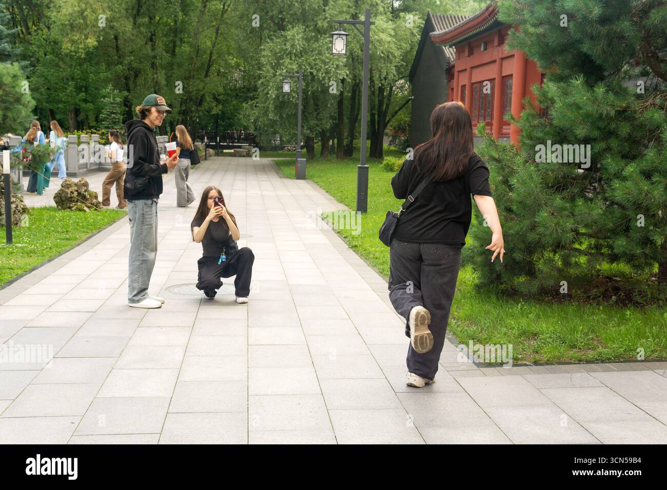 Moskau, Russland - 22. Juli 2025: Teenager machen Fotos in einem chinesischen Park Stockfoto