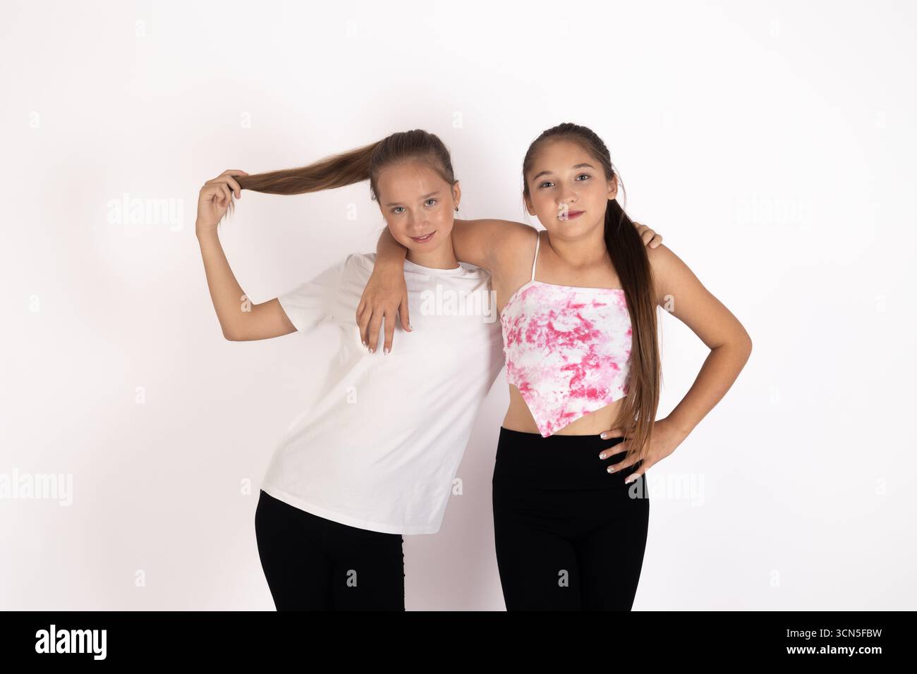 Mädchen in weißen Hemden und schwarzen Hosen posieren für die Kamera Stockfoto