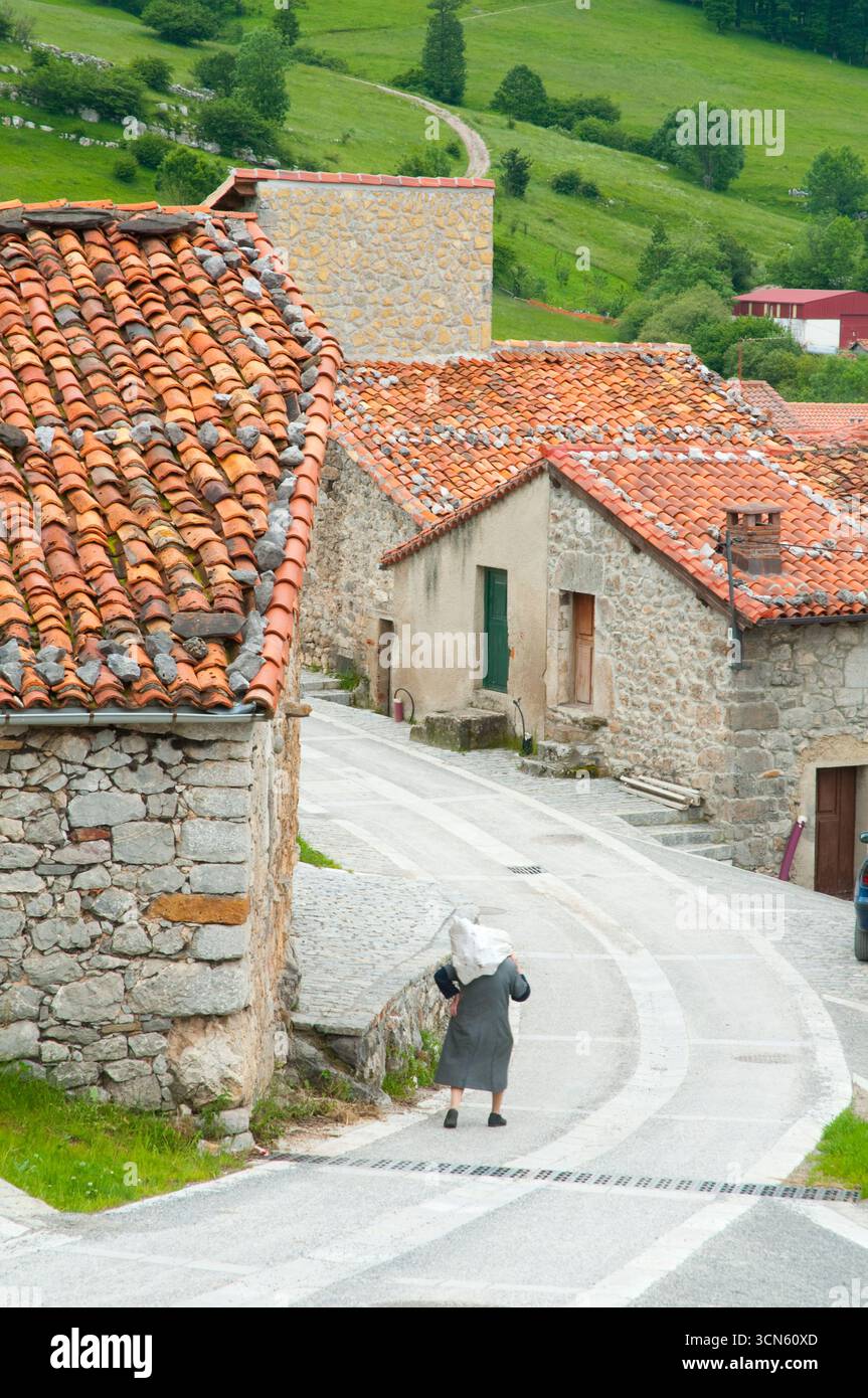 Eine alte Frau, die die Straße entlang läuft. Sotres, Asturien, Spanien. Stockfoto