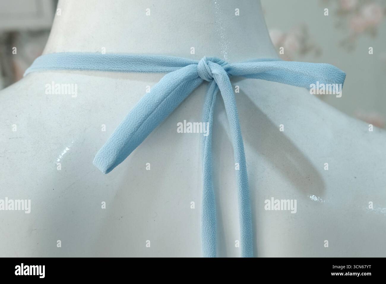 Das blaue Kleid ist um den Hals der Schaufensterpuppe gebunden. Stockfoto