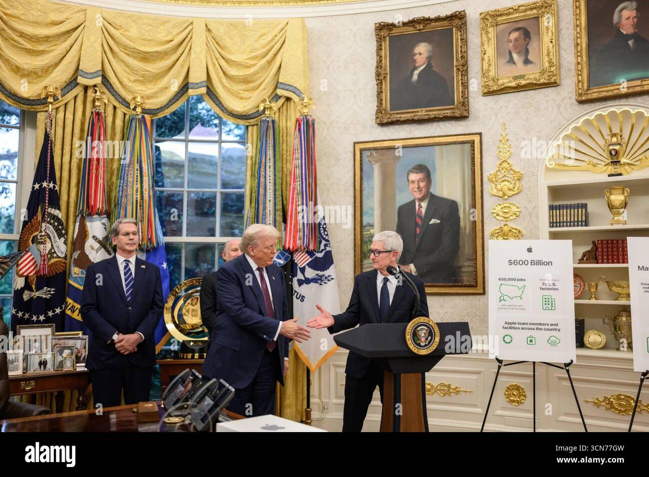 Präsident Donald J. Trump und Apple CEO Tim Cook tauschen während einer Veranstaltung im Oval Office einen Handschlag aus, in dem Apple's US-amerikanisches Herstellungsprogramm für 600 Milliarden US-Dollar und das Engagement für die Schaffung von Arbeitsplätzen in den USA hervorgehoben werden. Bild mit freundlicher Genehmigung des Weißen Hauses. August 2025. Stockfoto