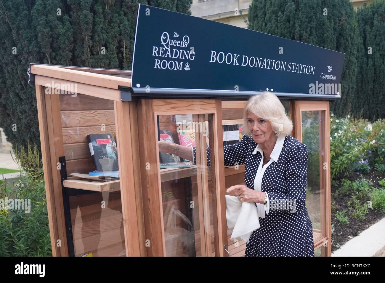 Queen Camilla platziert Bücher an einer Spendenstelle für den Queen's Reading Room, der zusammen mit allen während des Festivals an die Nutzer der Elm Foundation gespendeten Büchern im Chatsworth House in Bakewell, Derbyshire, verteilt wird. Bilddatum: Freitag, 19. September 2025. Stockfoto