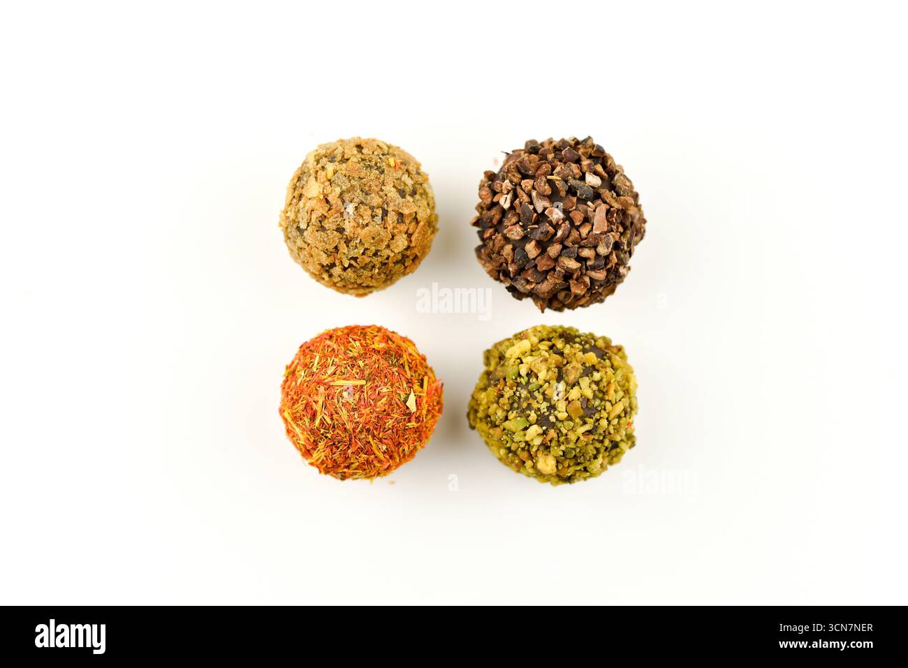 Vier verschiedenfarbige Kugeln Essen. Die Farben sind gelb, orange, grün und braun. Die Kugeln sind in einem Quadrat angeordnet Stockfoto