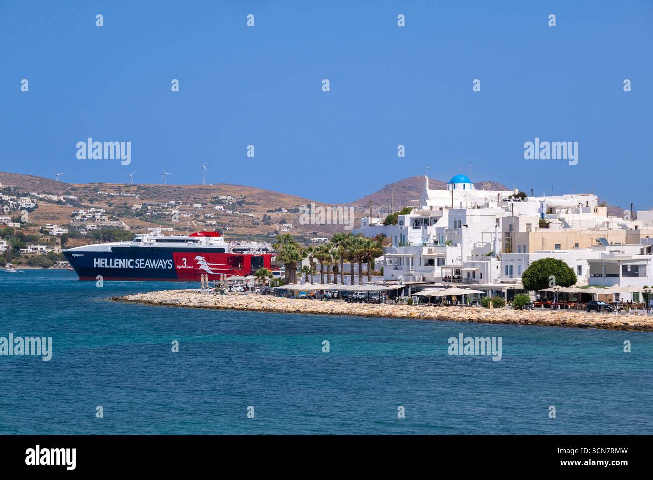 Parikia, Paros, GR - 22. August 2025: Allgemeiner Blick auf die Küste von Parikia mit einer Hellenic Seaways Fähre im Hintergrund Stockfoto