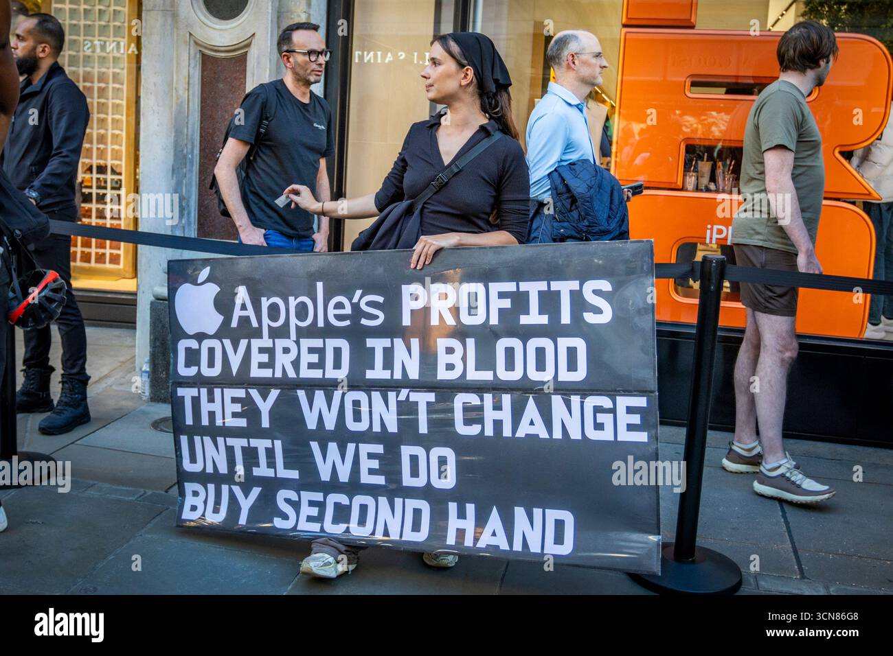 Aktivisten veranstalteten am 17. September einen Protest vor dem Apple Store in der Regent Street, Central London, während des Launch des iPhone 17. Demonstranten hielten Plakate, auf denen sie erklärten, dass das iPhone 17 mit Blut bedeckt ist, und beschuldigten Apple, vom Kobaltbergbau im Kongo im Zusammenhang mit Kinderarbeit und Menschenrechtsverletzungen profitiert zu haben. Die Warteschlangen von Kunden, die versuchten, den Regent Street Apple Store zu betreten, wurden mit Gesängen, Plakaten und Zuschauern getroffen, die sich versammelten, um den Protest zu beobachten. Stockfoto